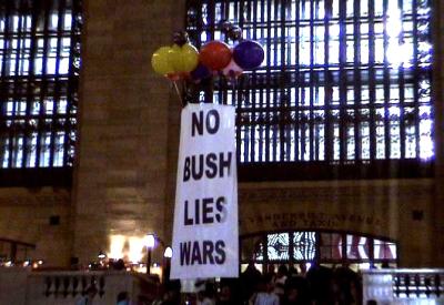 Act Up banner rises on balloons inside Grand Central Station.